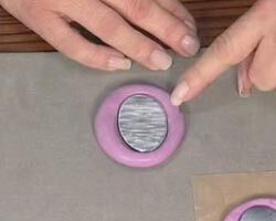 A hand is pressing its fingernail into the compound on the table.